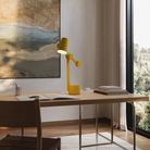 The mustard Aim Task Light from Gantri in a home office.