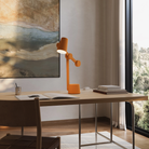 The persimmon Aim Task Light from Gantri in a home office.