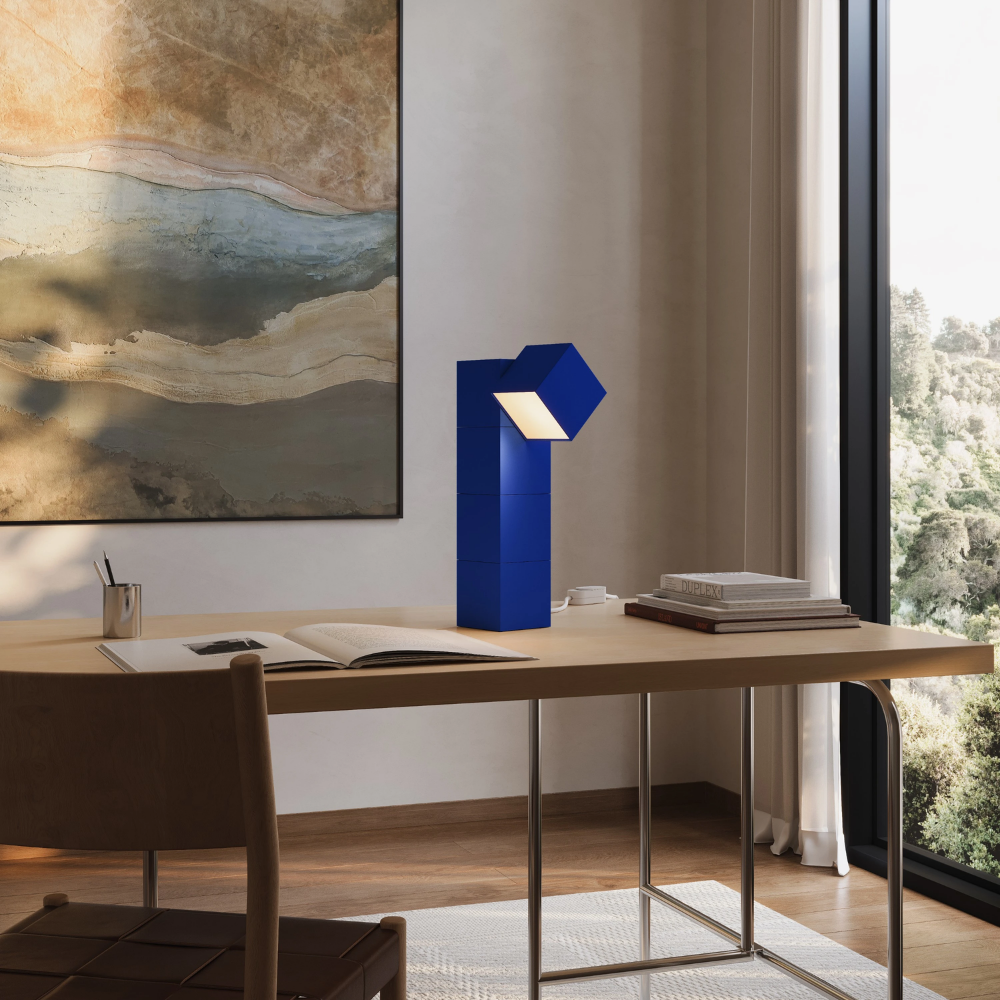The cobalt Analog Task Light from Gantri in a home office on top of a desk.