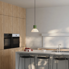The olive Buia Pendant Light from Gantri with the black cord in a dining and kitchen area above a kitchen bar.