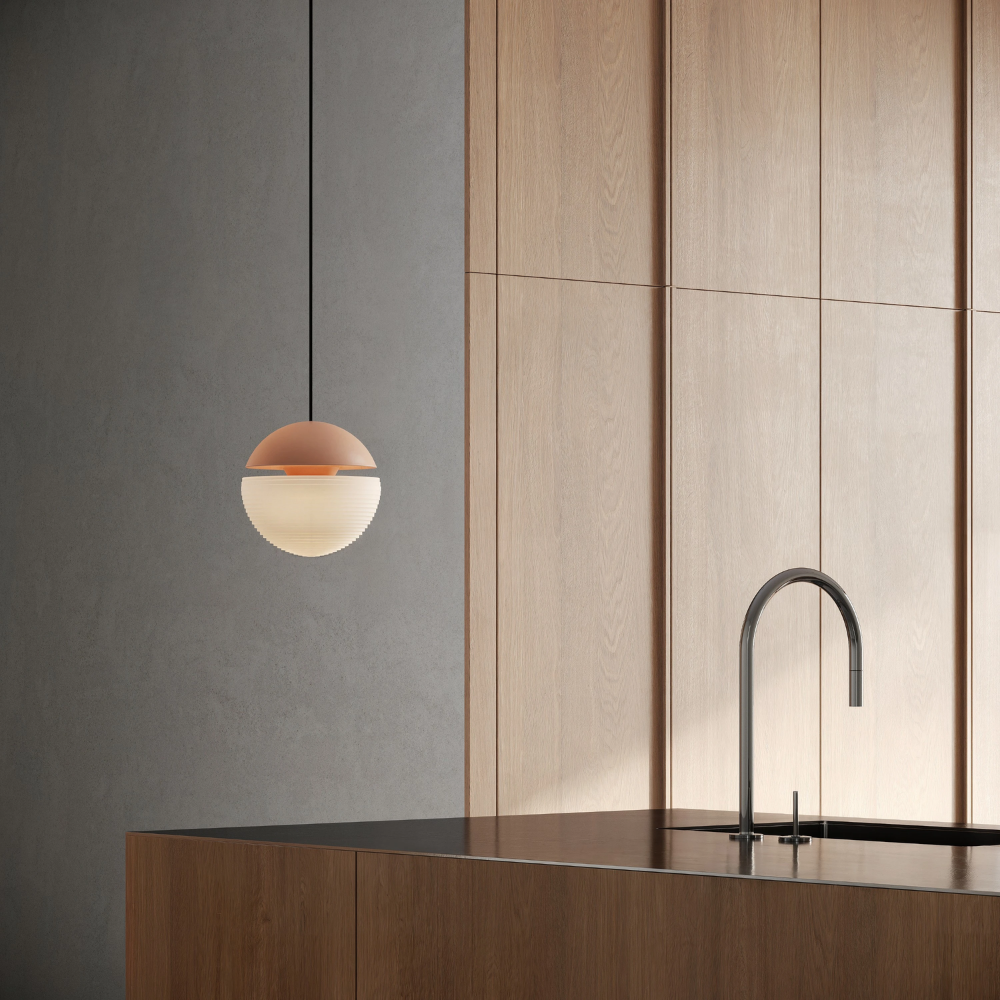 The blossom Cora Pendant Light from Gantri with the black cord in a kitchen and dining area above an island with a sink.