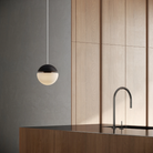 The carbon Cora Pendant Light from Gantri with the white cord in a living area.