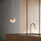 The coral Cora Pendant Light from Gantri with the white cord in a living room.
