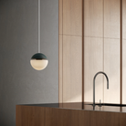 The forest Cora Pendant Light from Gantri with the white cord in a living room.