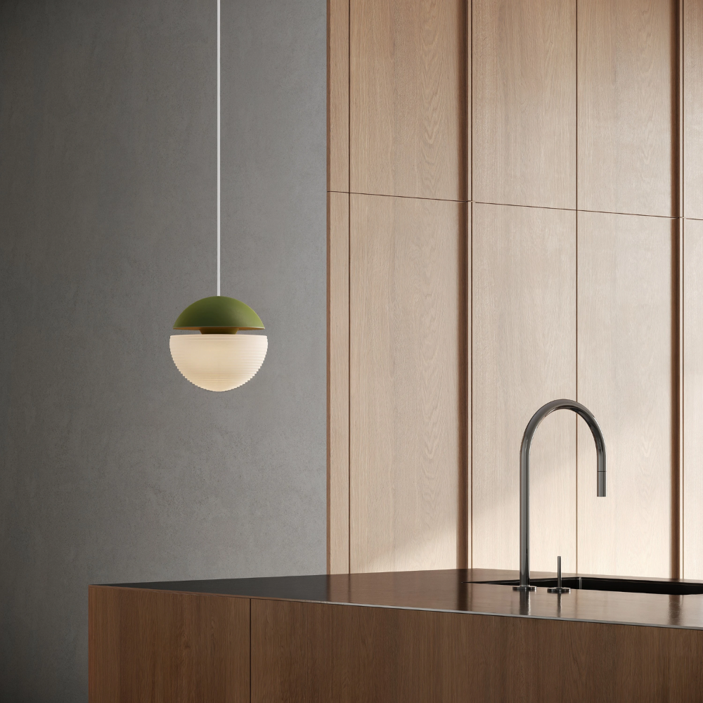 The olive Cora Pendant Light from Gantri with the white cord in a living room.