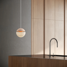 The peach Cora Pendant Light from Gantri with the white cord in a living room.