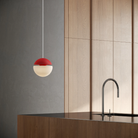 The poppy Cora Pendant Light from Gantri with the white cord in a living room.