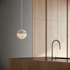The sky Cora Pendant Light from Gantri with the white cord in a living room.