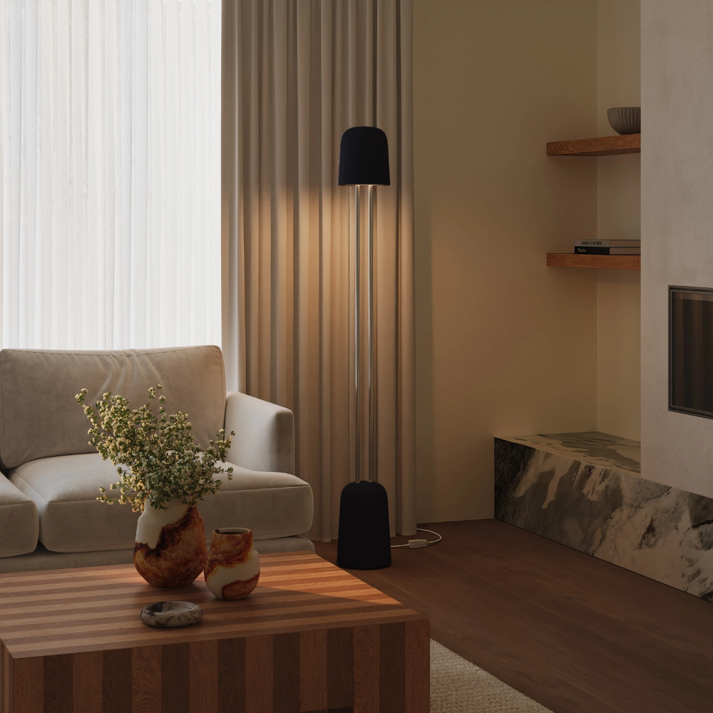 The carbon Gio Floor Light from Gantri with the chrome rod option in a family space beside a sofa.