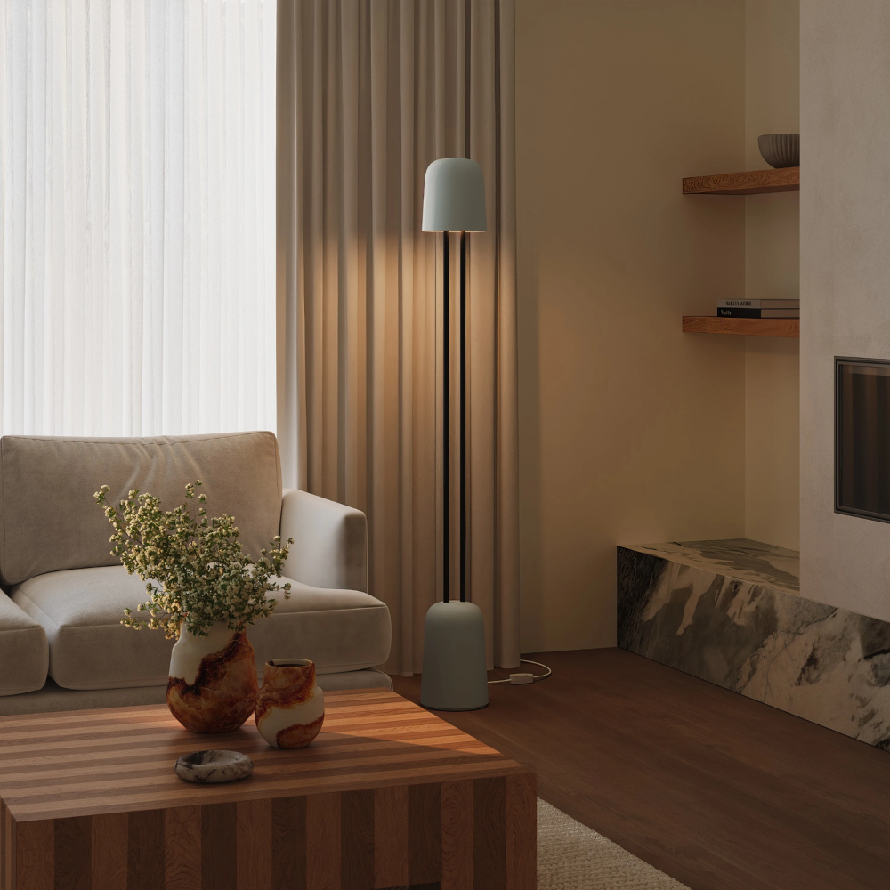 The mist Gio Floor Light from Gantri with the black rod option in a living room near a couch.
