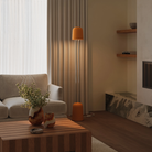 The persimmon Gio Floor Light from Gantri with the chrome rod option in a family space beside a sofa.