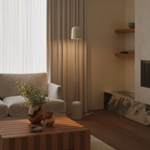 The sand Gio Floor Light from Gantri with the chrome rod option in a family space beside a sofa.