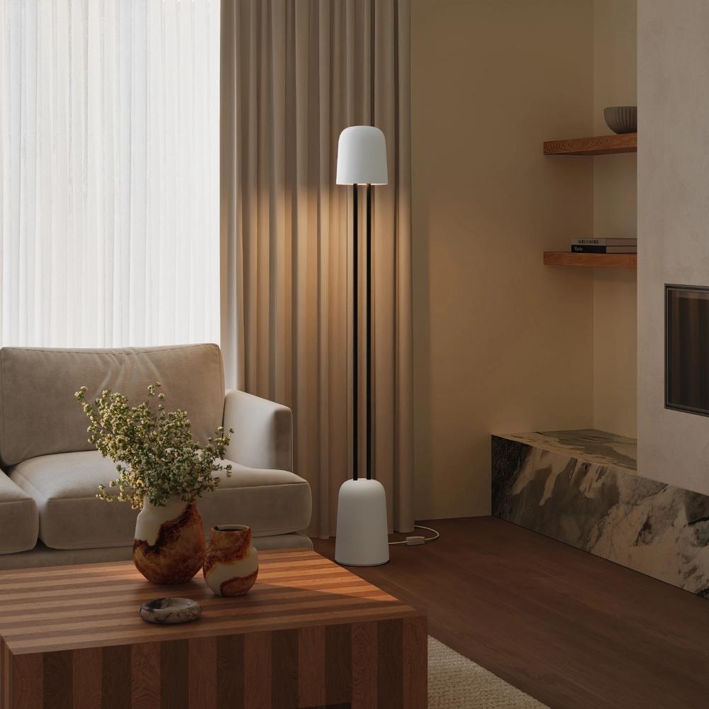 The snow Gio Floor Light from Gantri with the black rod option in a living room near a couch.