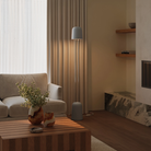 The stone Gio Floor Light from Gantri with the chrome rod option in a family space beside a sofa.