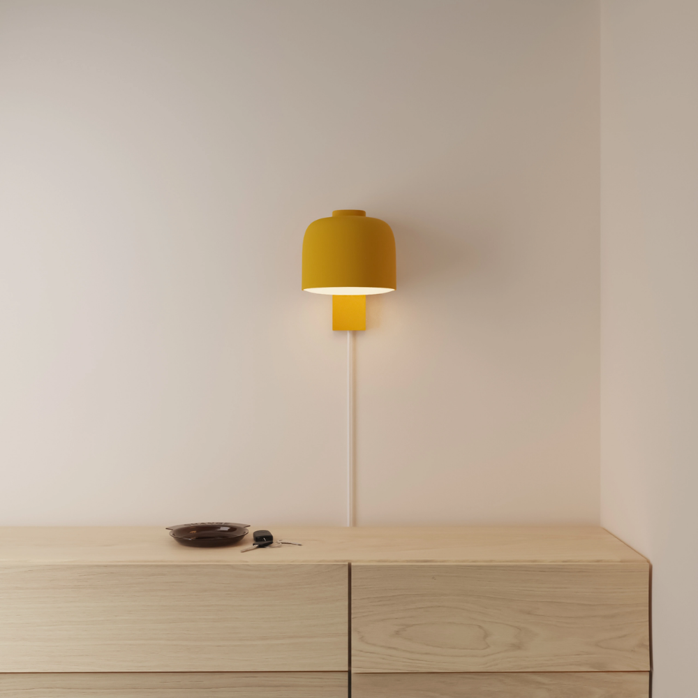 The mustard Gio Wall Light from Gantri in a primary bedroom.