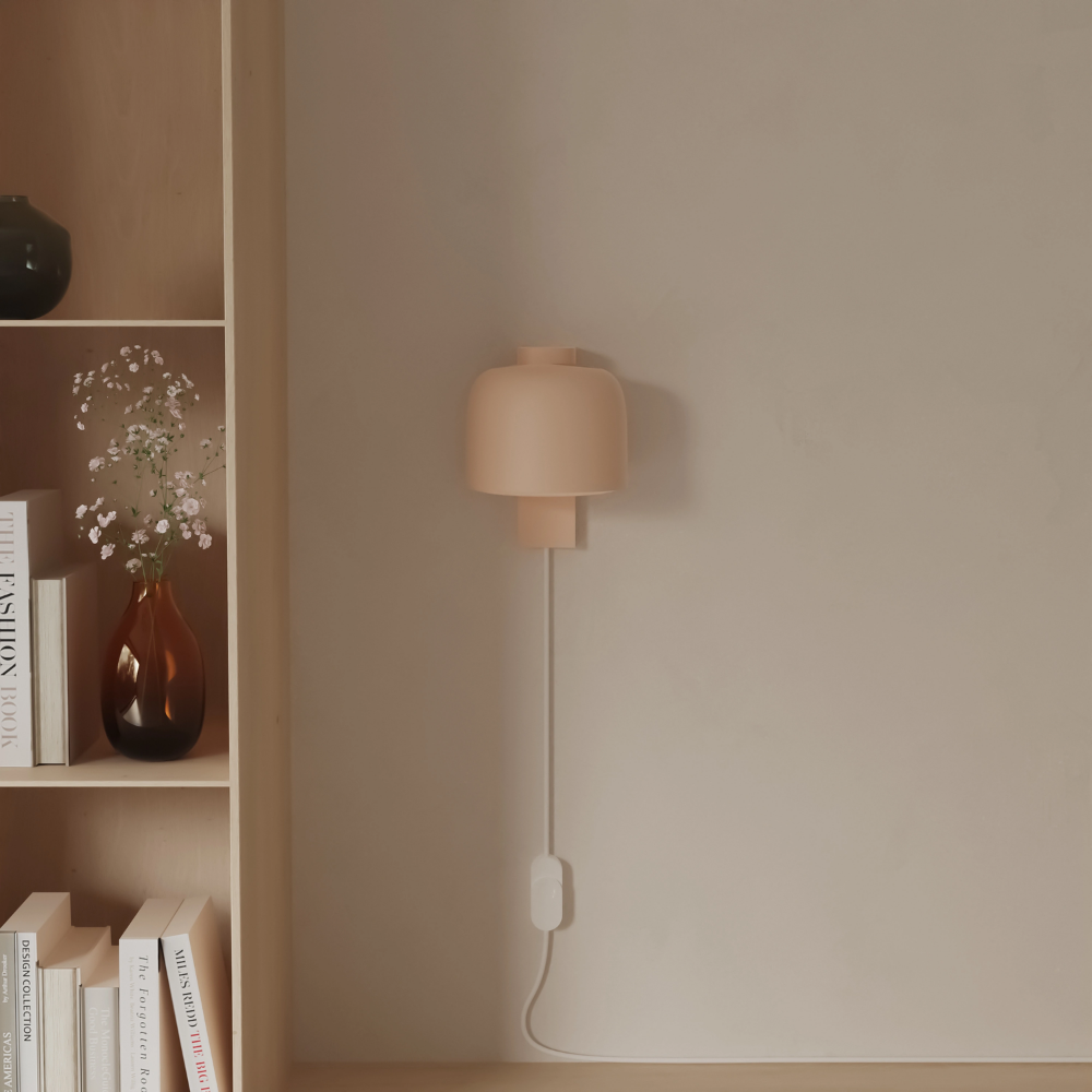 The peach Gio Wall Light from Gantri in a living room.