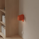 The persimmon Gio Wall Light from Gantri in a home office.