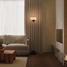 The carbon Kobble Floor Light from Gantri with the chrome rod option in a family area near a fireplace.