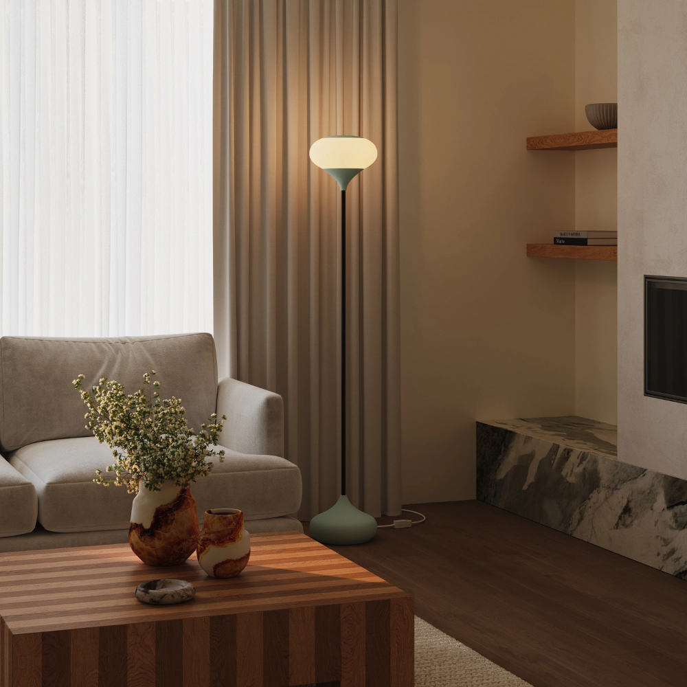 The meadow Kobble Floor Light from Gantri with the black rod option in a living room beside a couch.