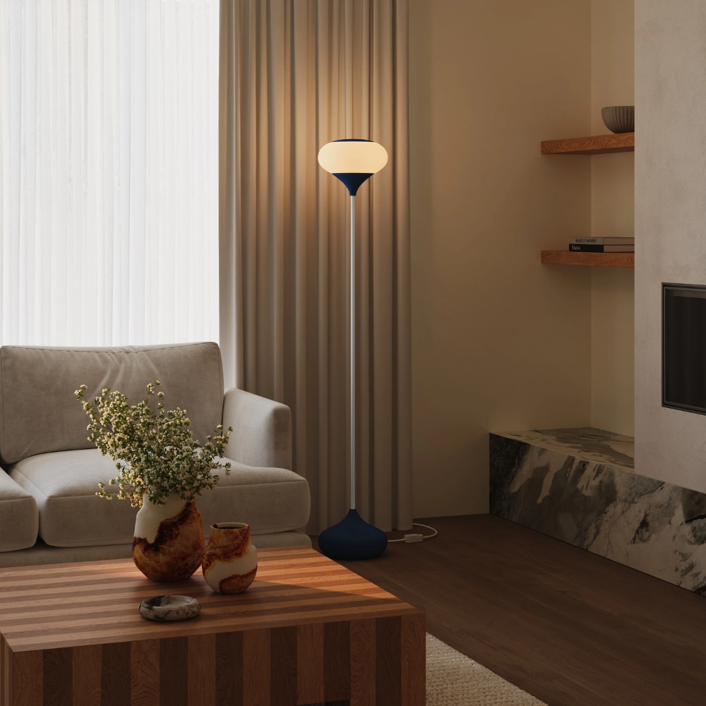 The midnight Kobble Floor Light from Gantri with the white rod option in a lounge space next to a sofa.
