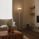 The sage Kobble Floor Light from Gantri with the white rod option in a lounge space next to a sofa.