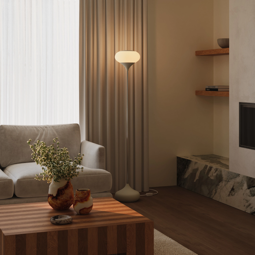 The sand Kobble Floor Light from Gantri with the chrome rod option in a family area near a fireplace.