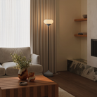 The stone Kobble Floor Light from Gantri with the black rod option in a living room beside a couch.