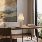 The Pleat Table Light from Gantri in a business space beside several books.