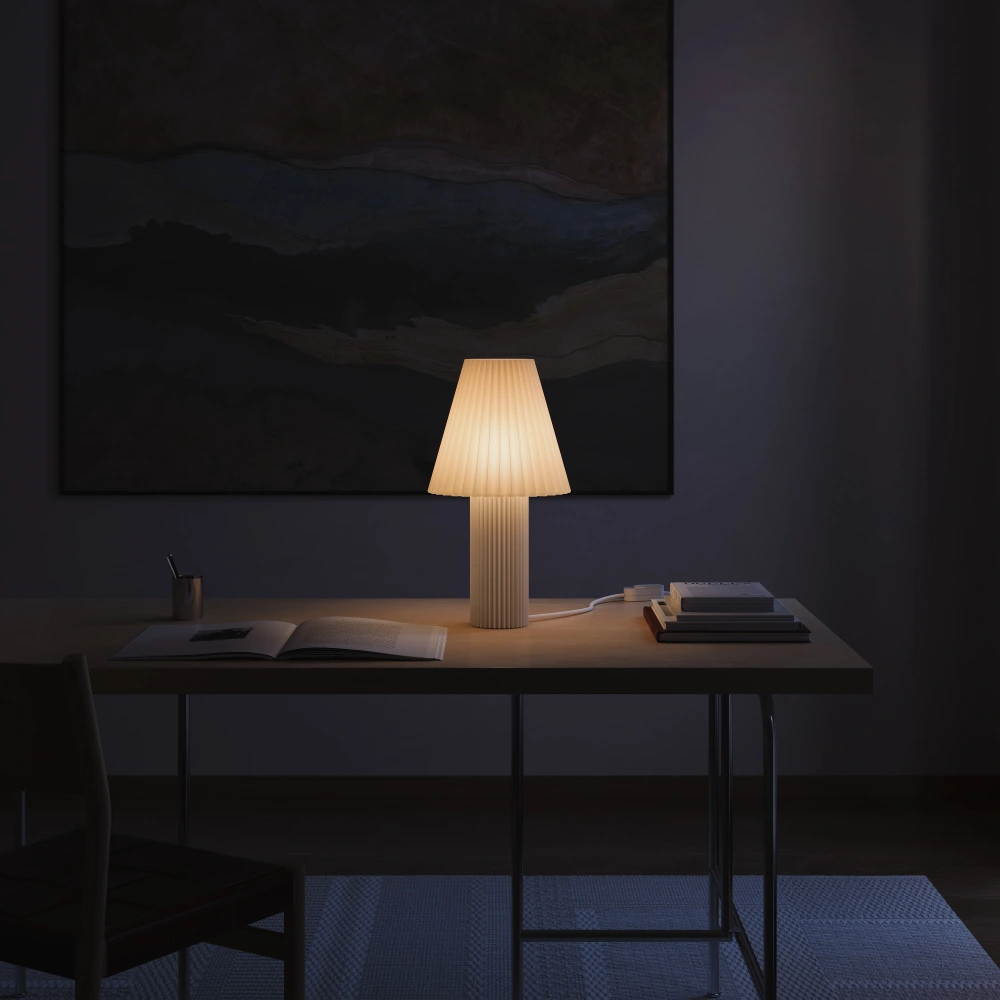 The Pleat Table Light from Gantri turned on, lighting up a dark living room.