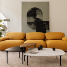 The low carrara marble table with bowl, mid black and high walnut Cyclade Tables from Herman Miller in a living space.