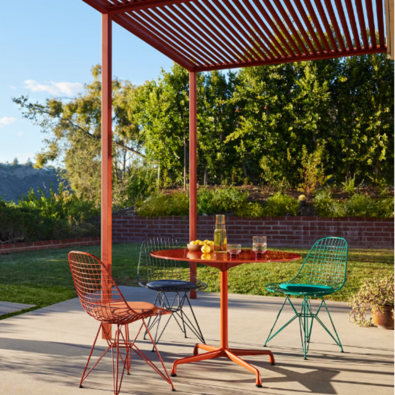 The Eames Dining Table from Herman Miller, designed by Herman Miller x Hay outdoors with the Eames Wire Chairs.
