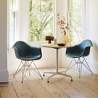 The evergreen shell Eames Molded Plastic Armchair Wire Base from Herman Miller in a living room.