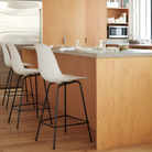 The white shell Eames Molded Plastic Bar Height Stool from Herman Miller in a family area.