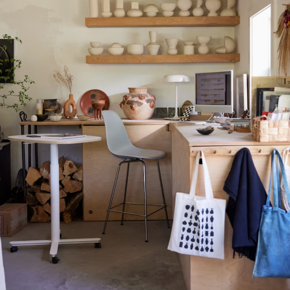 The gray green shell Eames Molded Plastic Counter Height Stool from Herman Miller in a home office.