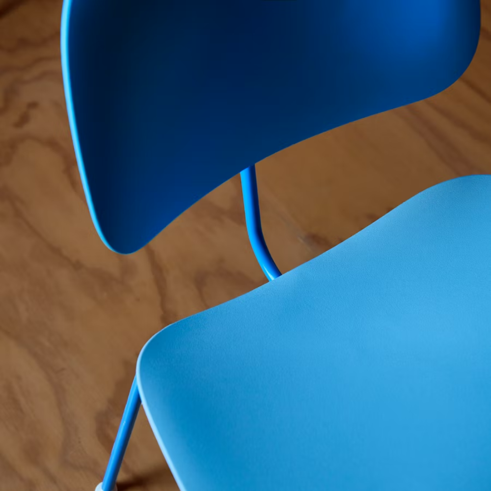 The Eames Molded Plastic Dining Chair from Herman Miller with the pale blue shell and berry blue leg finish in a dining room.