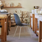 The medium gray shell Eames Molded Plastic Side Chair 4-Leg Base from Herman Miller in a living room.