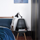 The black shell Eames Molded Plastic Side Chair Dowel-Leg Base from Herman Miller in a primary bedroom.
