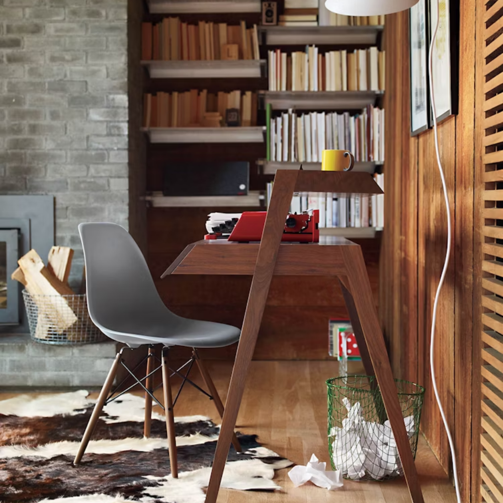 The light gray shell Eames Molded Plastic Side Chair Dowel-Leg Base from Herman Miller in a home office.