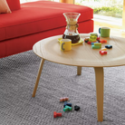 The white ash Eames Molded Plywood Coffee Table from Herman Miller in a family area. all-groups