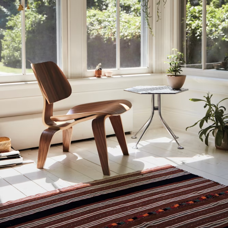 The Santos Palisander Eames Molded Plywood Lounge Chair Wood Base from Herman Miller in a family area.