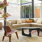 The Santos Palisander Eames Molded Plywood Lounge Chair Wood Base from Herman Miller in a living room.