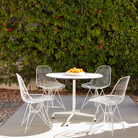 The white Eames Outdoor Wire Chair from Herman Miller in an outdoor dining area.