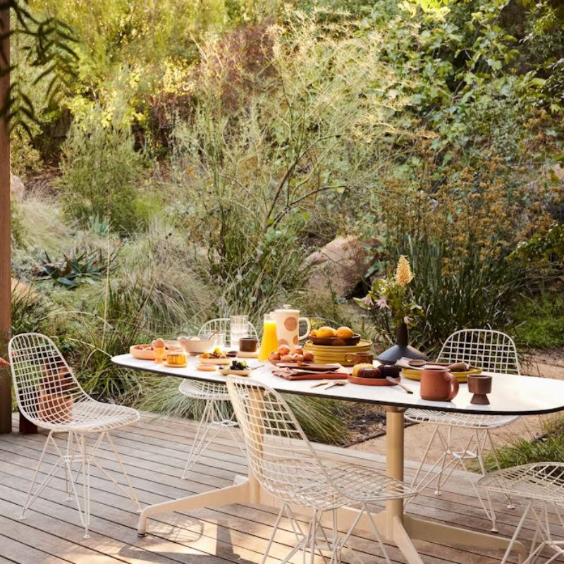 The white Eames Outdoor Wire Chair from Herman Miller in an outdoor lounge space.