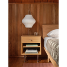 The Nelson Pear Wall Sconce from Herman Miller next to a bed.