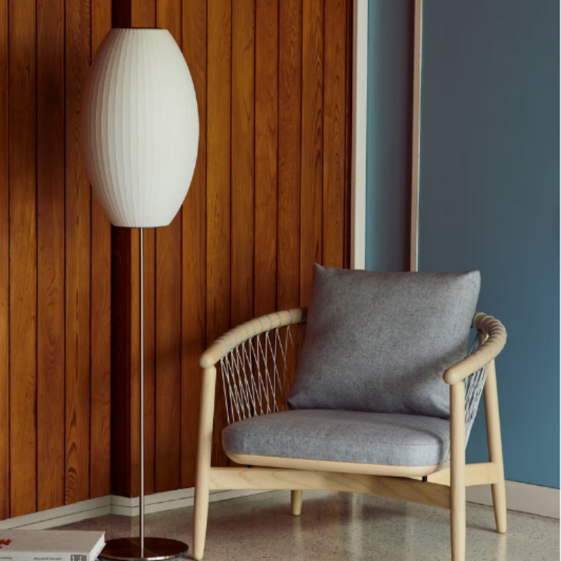 The medium brushed nickel Nelson Cigar Lotus Floor Light from Herman Miller in a lifestyle photograph within a den. 