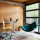 The Nelson Coconut Chair from Herman Miller with the denim mode upholstery and white base in a living area.