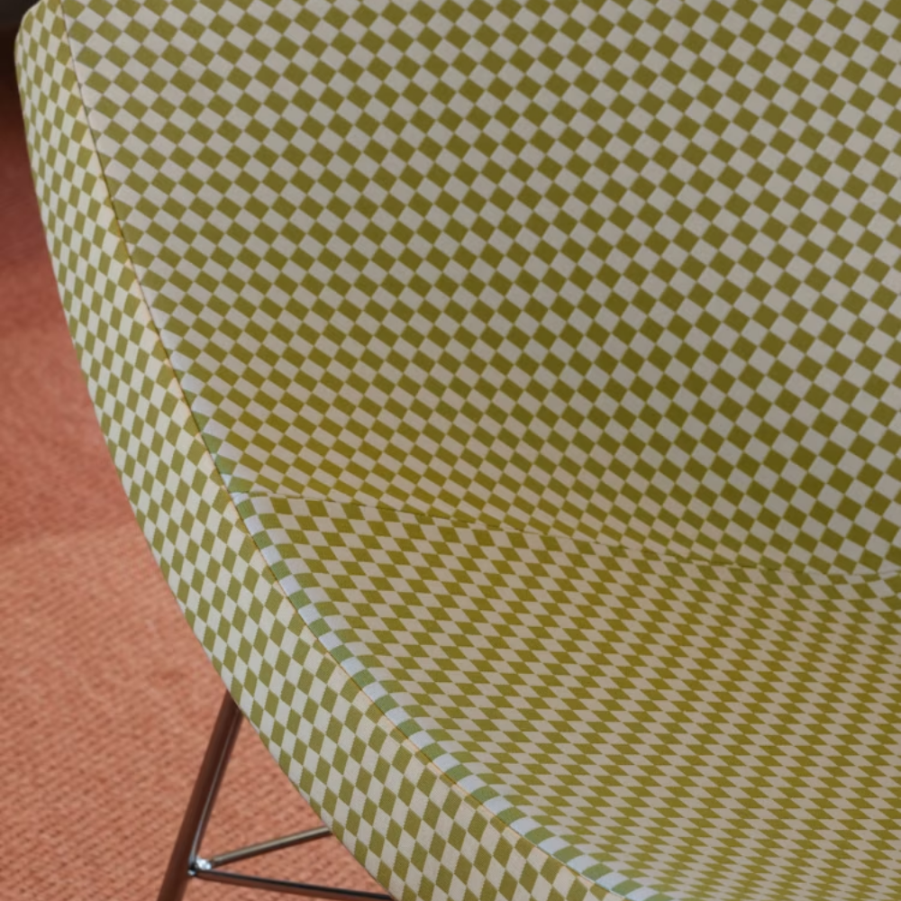 The Nelson Coconut Chair from Herman Miller with the light emerald and ivory checker upholstery and chrome base close up.
