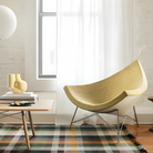 The Nelson Coconut Chair from Herman Miller with the light emerald and ivory checker upholstery and chrome base in a family area.