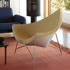 The Nelson Coconut Chair from Herman Miller with the light emerald and ivory checker upholstery and chrome base in a living room.