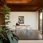 The walnut and black Nelson X-Leg Table from Herman Miller in an open space home.